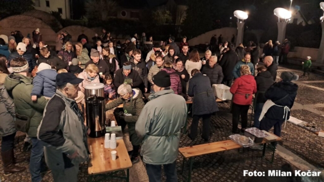 obiskovalci prireditve se družijo ob vročem čaju in krompirju