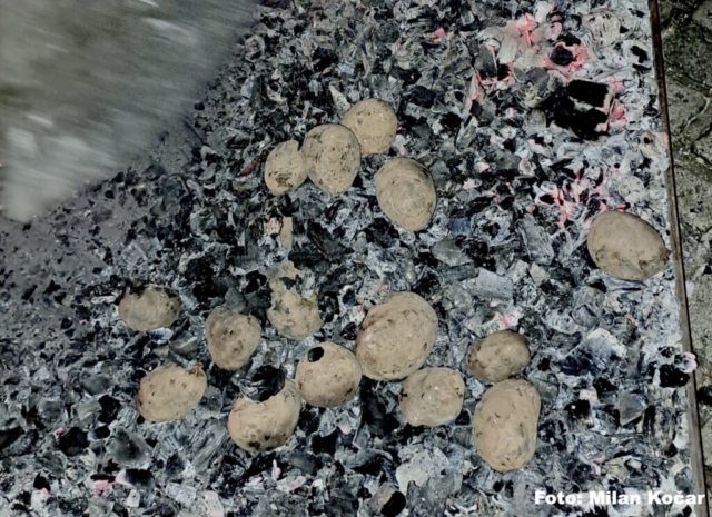 v žerjavici pečen krompir, ki ga pred postrežbo prerežejo in obogatijo z zaseko