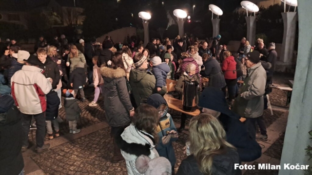 obiskovalci prireditve se družijo ob vročem čaju in krompirju